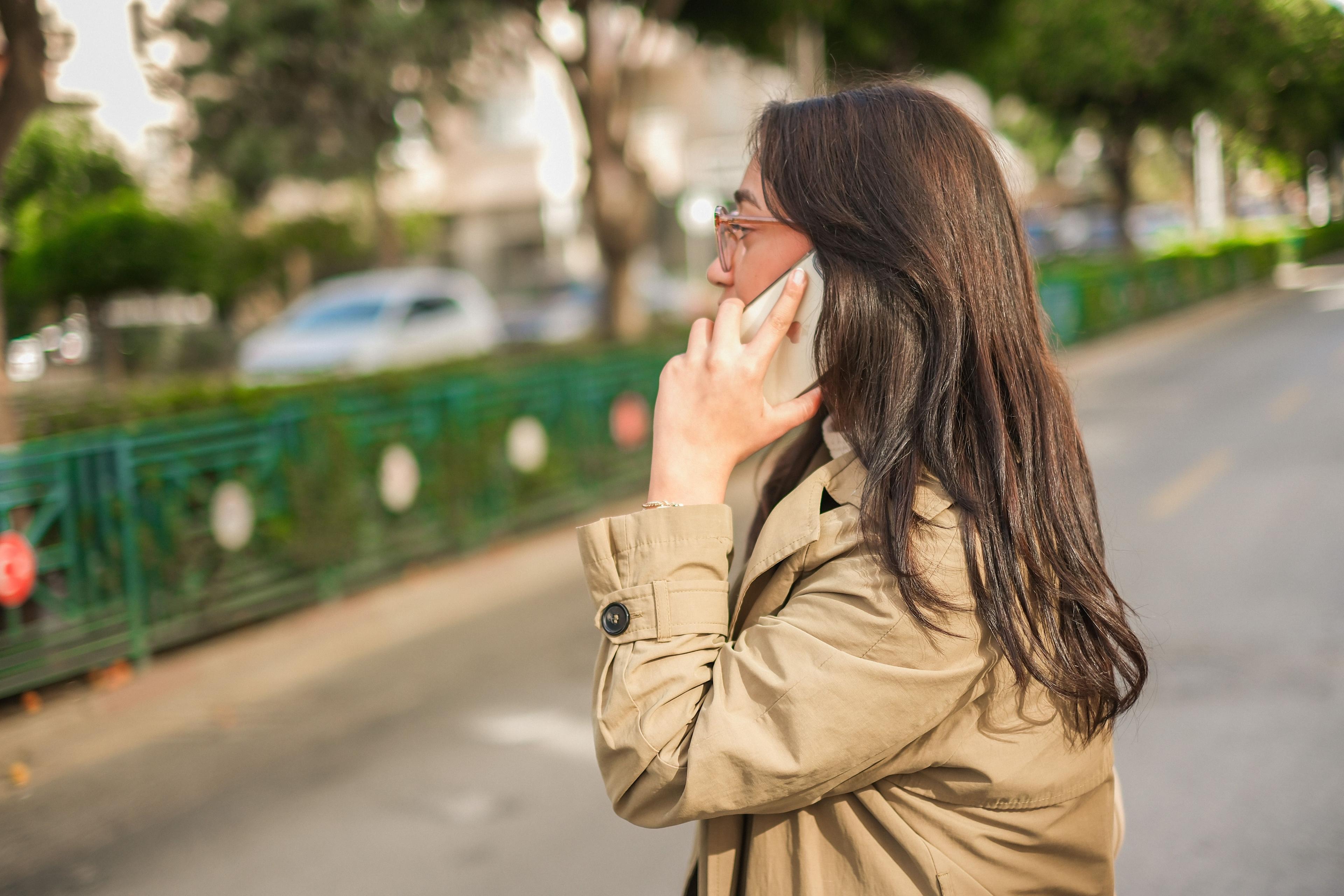 Femme au téléphone dans la rue, en pleine gestion de son activité